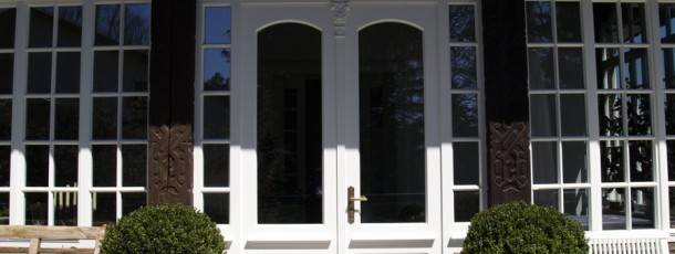Manufakturfenster Terassentür und geschnitzte Säulen mit Drachenköpfen